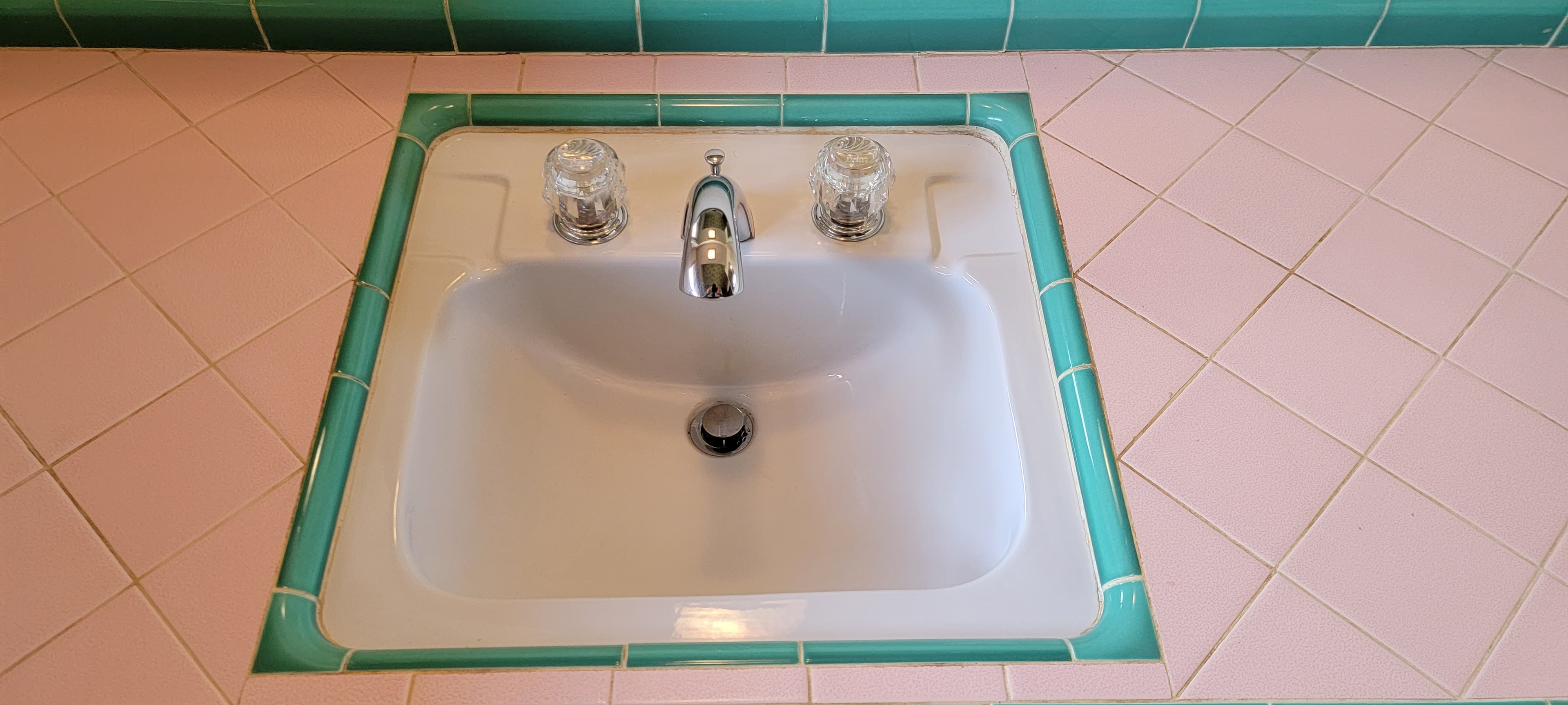 Pink tile sink after deep cleaning, with the basin and counter restored